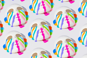 Creative pattern with face mask and colorful paint on a white background. Halloween or Santa Muerte concept.