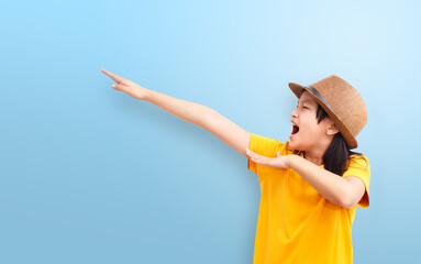 Asian girl makes a dab movement and open her mouth for shouting on a light blue background. Human emotions, facial expression concept.