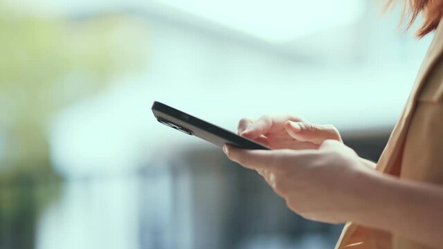 Close up hands of woman holding mobile smartphone in hands, scrolling personal page in social network, looking at photos, reading news in media, web surfing information.