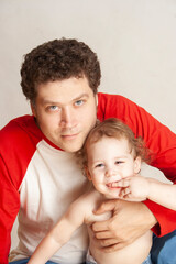 portrait of young father with happy baby looking at camera baby riding on his young father's shoulders