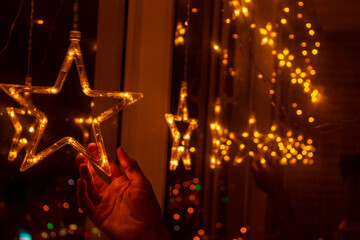 Stars in the window . Christmas decoration with garland lights and stars at winter seasonal holidays