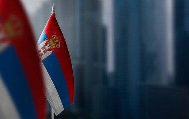 Small flags of Serbia on a blurry background of the city