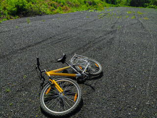 Yellow mountain bike lying on loose road surface, no travel concept