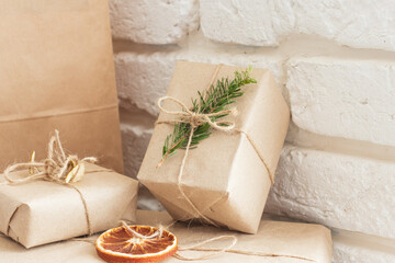 Christmas composition. Christmas gift, knitted blanket, pine cones, fir branches on wooden white background. Flat lay, top view, copy space