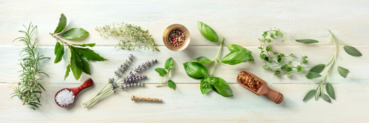 Fresh herbs panorama, shot from the top on a wooden background with salt and pepper. Rosemary, lavender, bay leaf, thyme, basil, sage etc