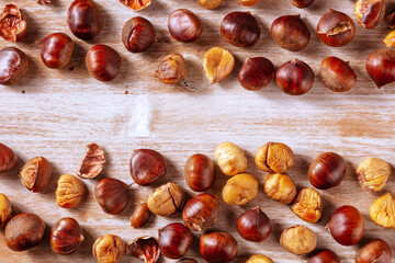 Chestnuts banner with copy space, a design template for an autumn menu or invitation, overhead flat lay shot on a rustic wooden background