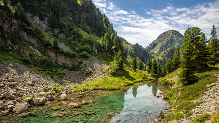 Fototapeta na wymiar Paysage de randonnée au lac Léama (Chamrousse, alpes, France) sous un joli ciel bleu d'été
