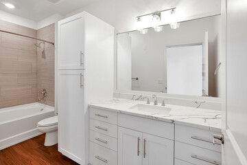 white bathroom with one sink, and granite countertops
