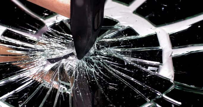 a hammer hitting a mirror, a lot of cracks and debris appear after being hit