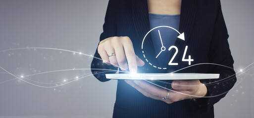 Business button 24 hours service. White tablet in businesswoman hand with digital hologram 24/7 all day all night icon on grey background. Full time service concept