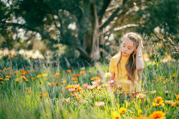 Portrait of pretty girl with vibrant orange and yellow wildflowers