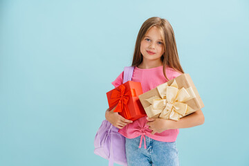 White blonde girl wearing pink t-shirt posing with gift boxes