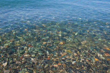 Stones in clear water of sea, water background