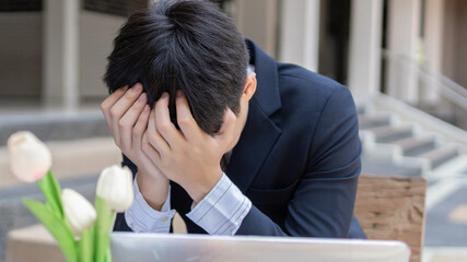 Businessman concept the businessmen using his both hands covering the forehead feeling desperate because of encountering the biggest problem