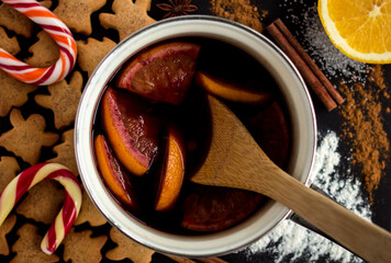 top view of freshly cooked mulled wine with orange slices in a saucepan, flat lay of grog or punch...