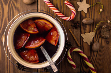 top view of freshly cooked mulled wine with orange slices in a saucepan, flat lay of grog or punch...