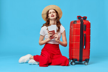 woman with red suitcase passport and plane tickets vacation destination