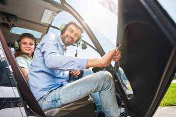 Cheerful airman and young woman sitting in chopper © Svitlana