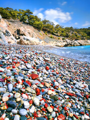 A pebble beach with colored round pebbles near the Mediterranean sea