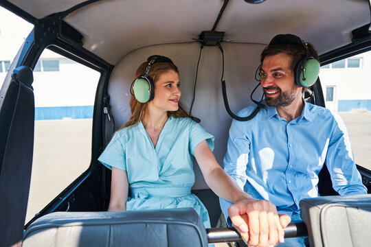 Happy romantic young couple anticipating helicopter flight