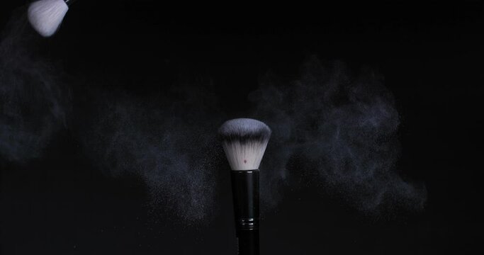 Cleaning the makeup brush with another brush, the remains of powder scatter