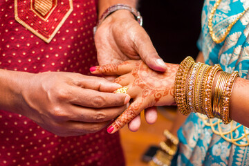 Indian newlyweds wearing rings to each other 