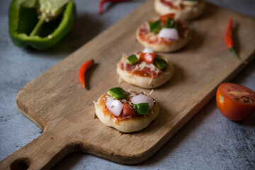 Italian snack mini vegetable pizzas on a cutting board. Close up.