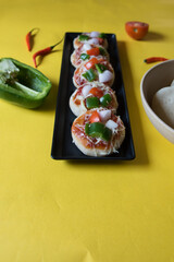Delicious pizzas arranged on a black tray . Close up view.