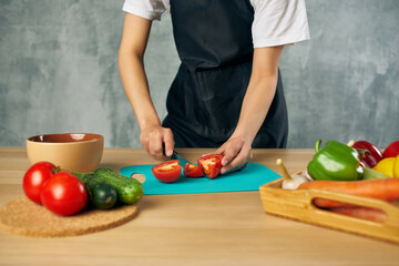 housewife on the kitchen cutting vegetables cutting board