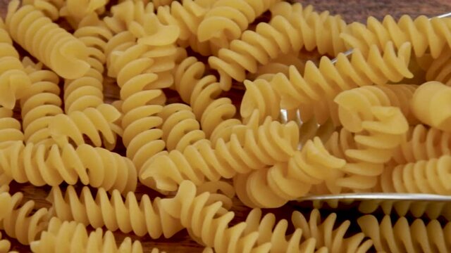 tas de fusilli crues sur un fond en bois	