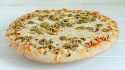 Pizza with green olives and mozzarella cheese on white wooden background.