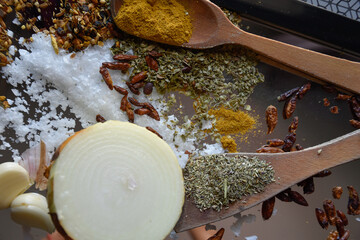 Cebolla partida por la mitad con ajos y varias especias y hierbas aromáticas para cocinar comida picante
