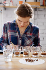Pretty female barista at coffee cupping test