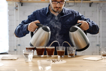 Barista pouring water to coffee cups