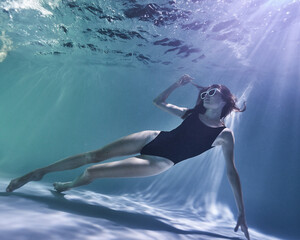fashion girl posing in the pool underwater