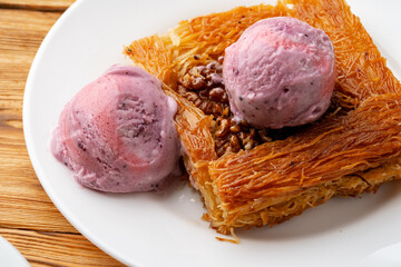 Turkish dessert kunefe served with ice cream on wooden background