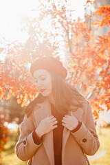 young woman wearing red beret walking in autumn park