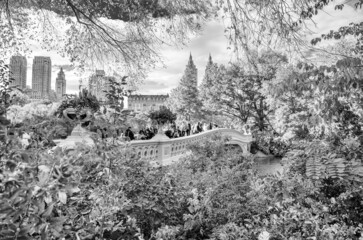 NEW YORK CITY, USA - OCTOBER 25TH, 2015: Tourists walk along Central Park Bow Bridge in foliage season. It is a main city attraction.