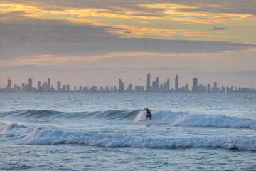 Unidentified surfers catching waves off Coolangatta Beach with the Gold Coast in the background at...