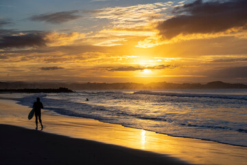 Fototapeta na wymiar Unidentified surfers silohuettes on Coolangatta Beach in Queensland with a dramatic sunset