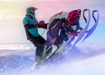 a snowmobiler rides and jumps in the snowy mountains. prof pilot of a mountain snowmobile in bright...