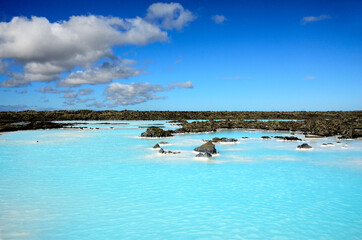 Naklejka premium Blue landscape, blue sky, Blue lagoon geothermal springs and black lava covered with moss in between, Iceland, Europe