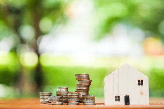wooden house with stack of coins. Saving Money for Investment property Concept.