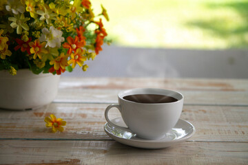   White cup of coffee on wood table on nature background,