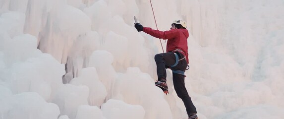 Man climb high ice wall winter sport evening training Alps exercise