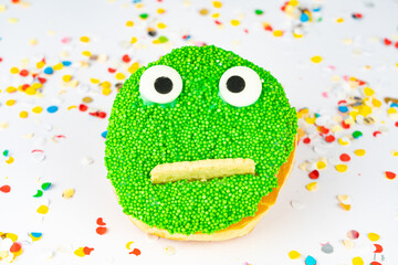 Funny green face cake with confetti background