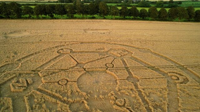 Crop circle Fortnite molecular geometry pattern aerial view on Wiltshire sunset wheat field countryside rising fast pull away