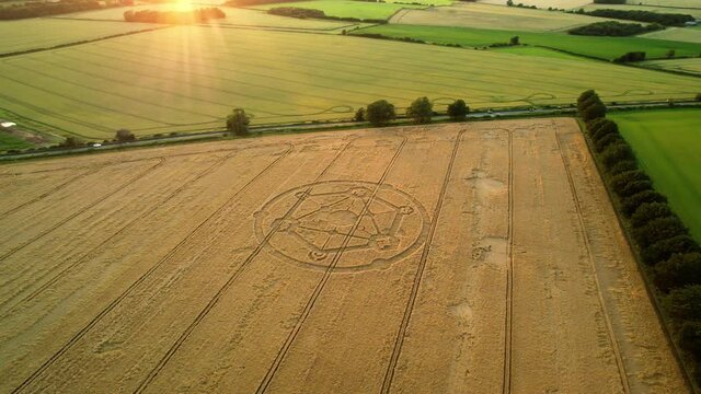 Crop circle Fortnite molecular geometry pattern aerial view on Wiltshire sunset wheat field countryside distant orbit right