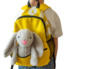 Bunny toy in a boy's backpack over white background. Back to school concept.