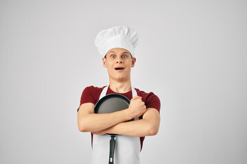 man chef hugging frying pan cooking light background